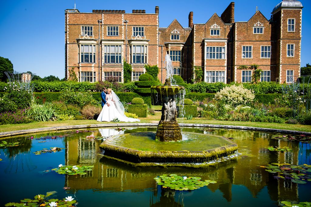 bride and groom infant of hatfield house at The Riding School Hatfield house wedding in hertfordshire