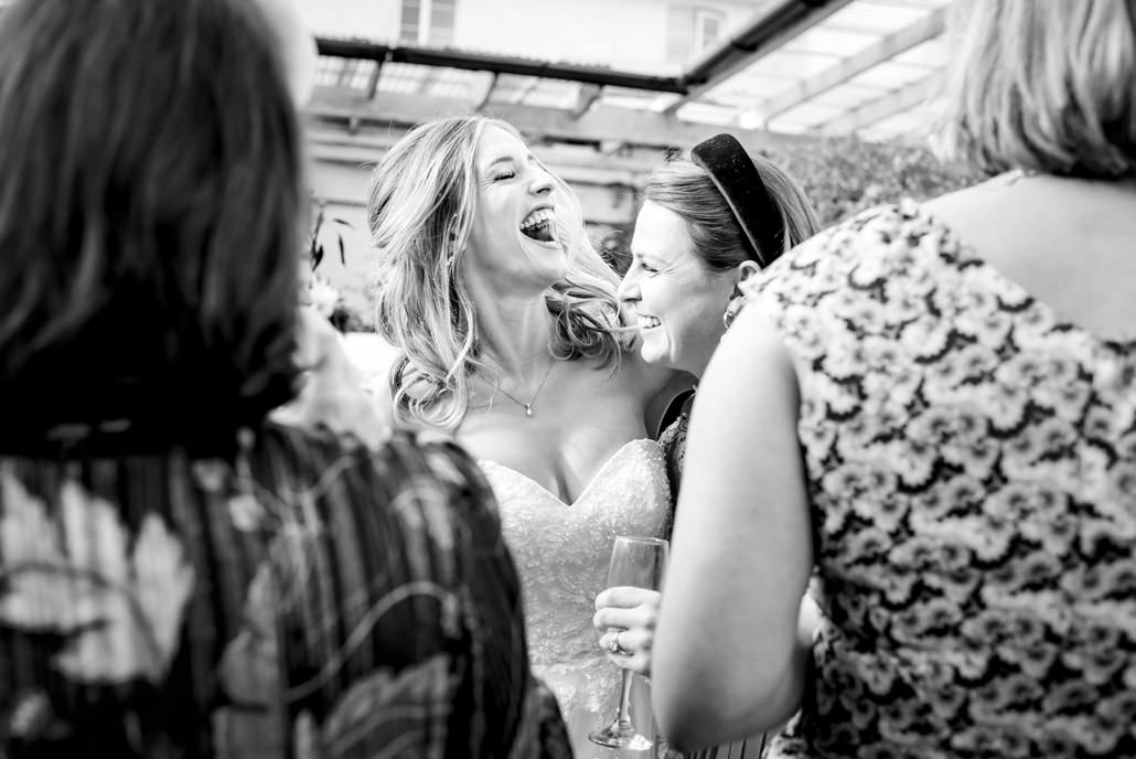 bride laughing with guests at Dyrham Park Country Club in Barnet