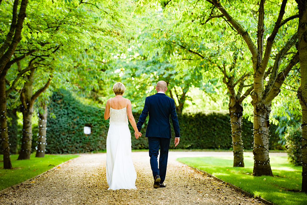 bride and groom walk at Autumn wedding at South Farm in Hertfordshire