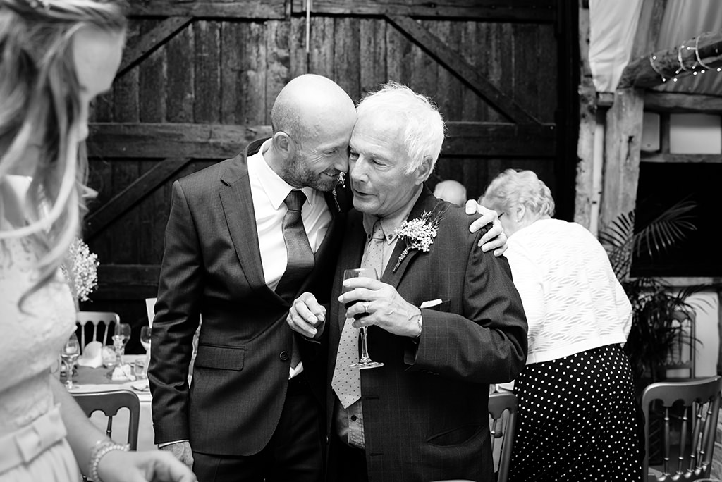 Groom hugs Dad at Autumn wedding at South Farm in Royston Hertfordshire