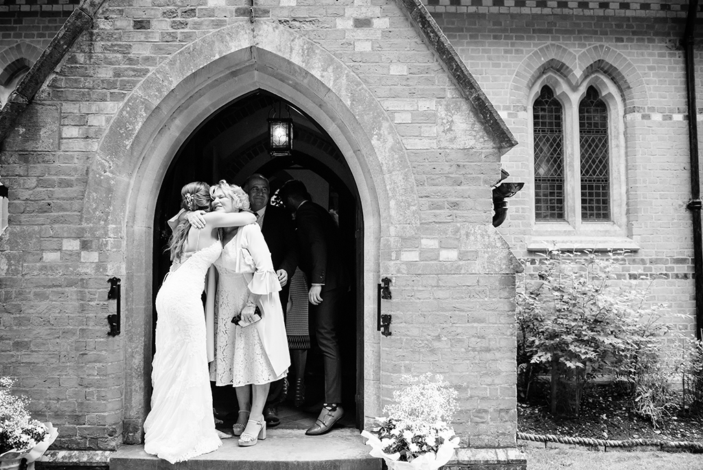 guests congratulate bride at Ayot St Lawrence church in Hertfordshire