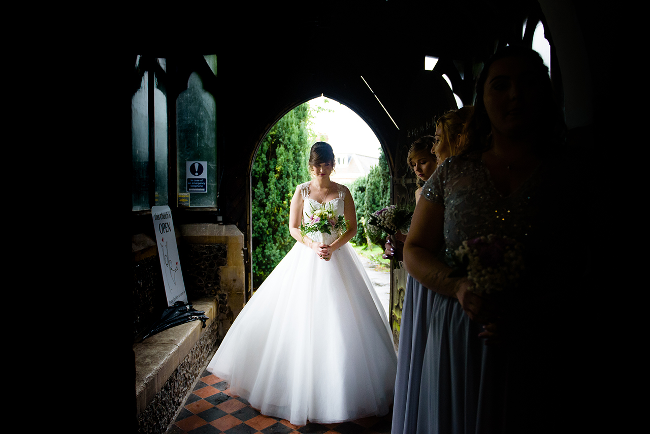 bride enters church at St Elthandreds church in hatfield, Hertfordshire