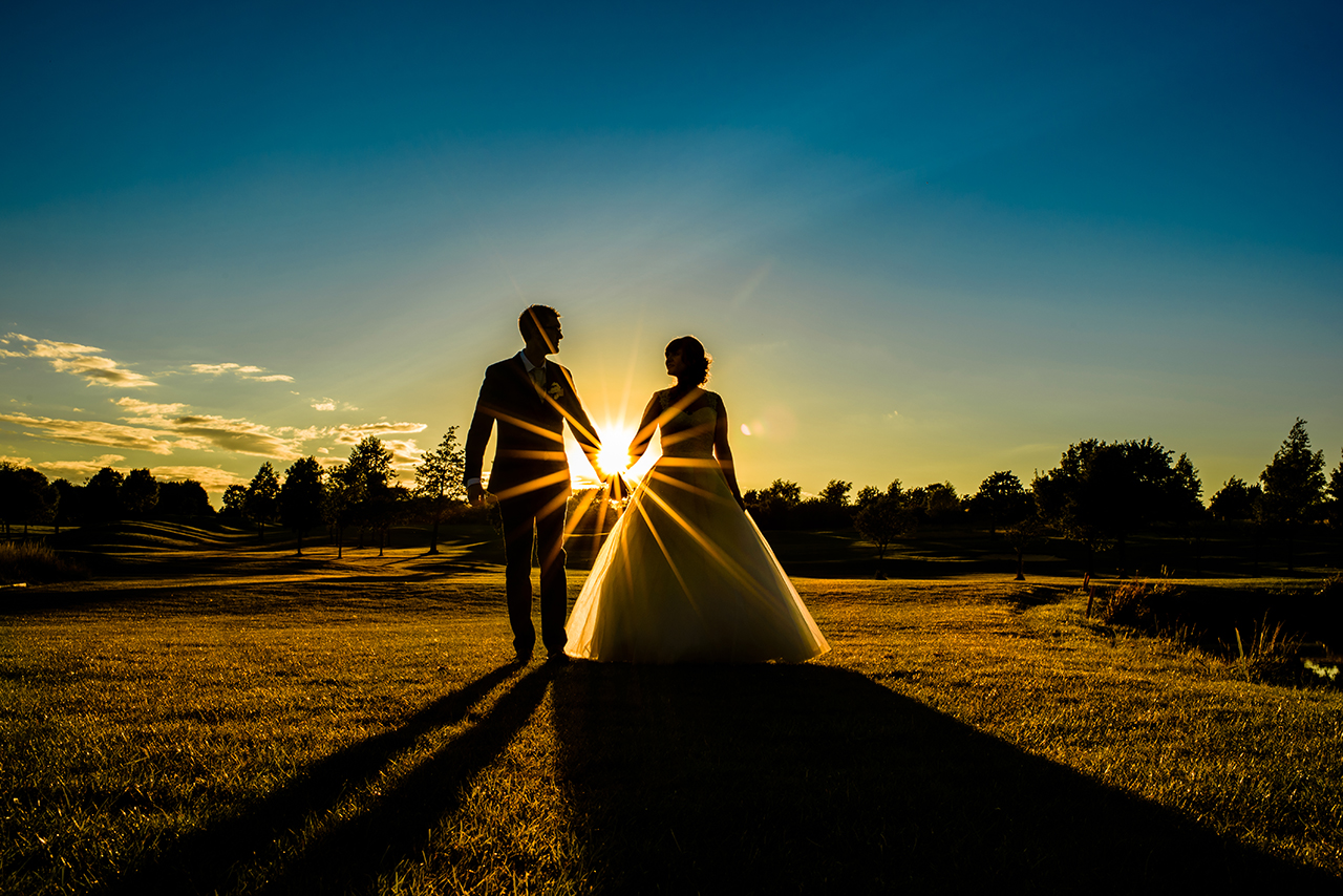 bride and groom walk in sunset at chesfield downs wedding venue in hertfordshire