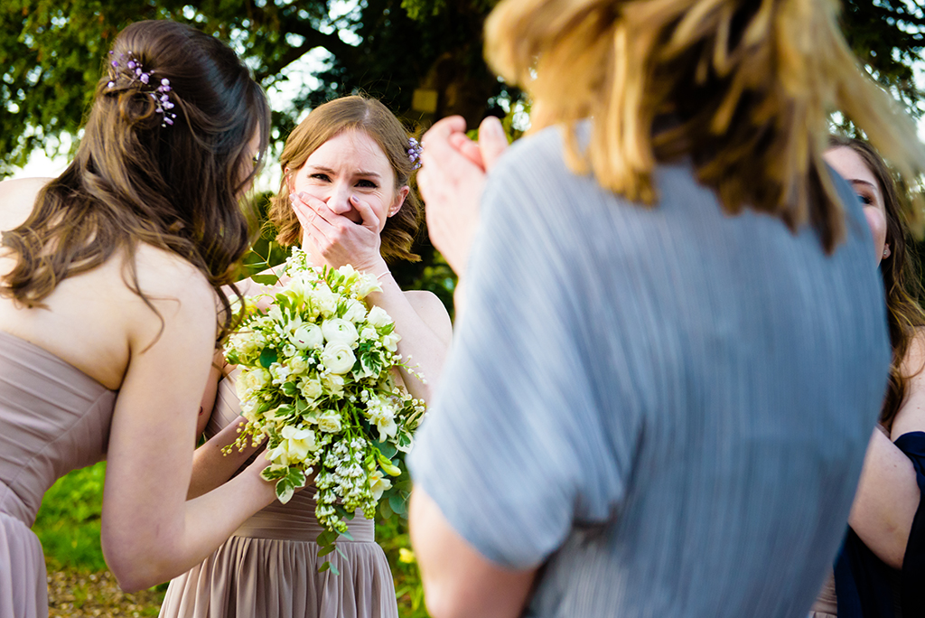 bridesmaid accidentally catches bouquet at Hastoe village Hall in Hertfordshire