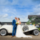 Bride and Groom pose with vintage car at Milling Barn wedding venue in Hertfordshire